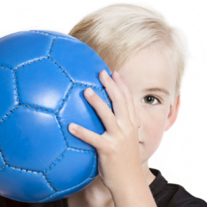 kid hiding behind soccer ball